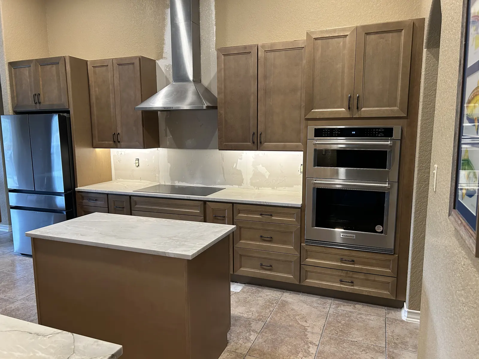 Boerne kitchen after remodeling with stained wood cabinets and a stone faced island