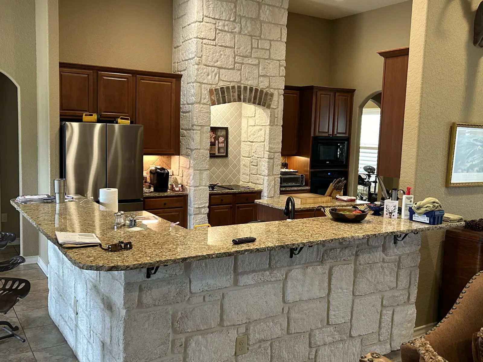 Boerne kitchen before remodeling with dark cabinets and a stone bar
