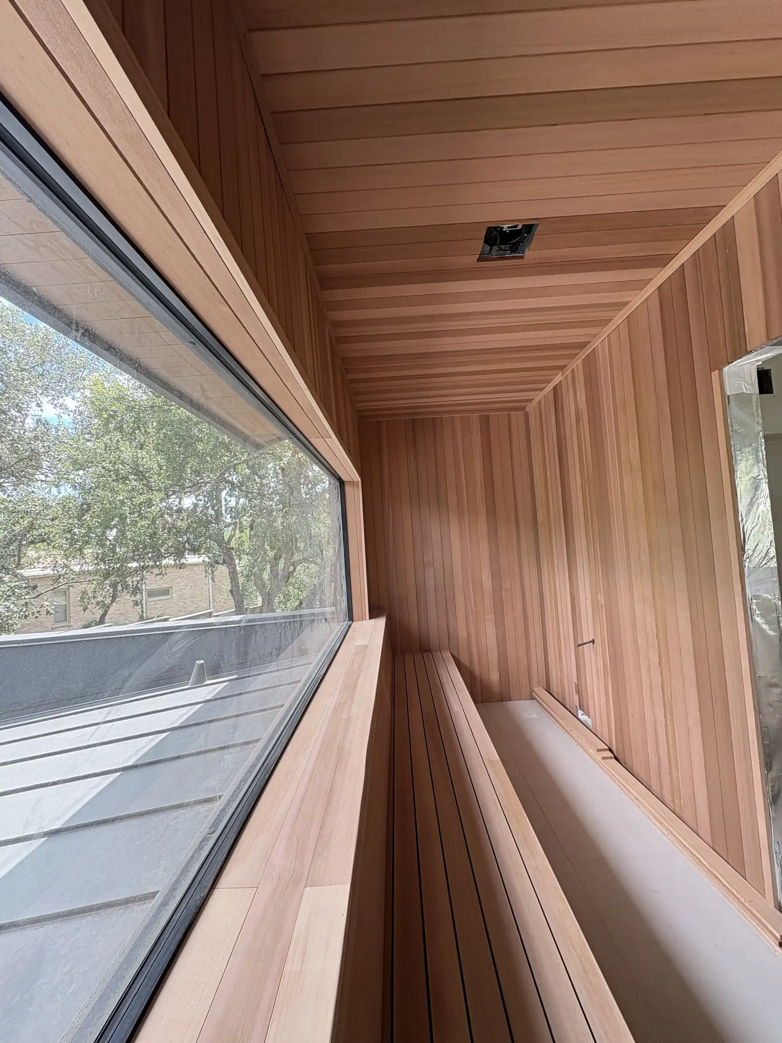 Cedar sauna interior with tongue and groove walls and a hand built bench
