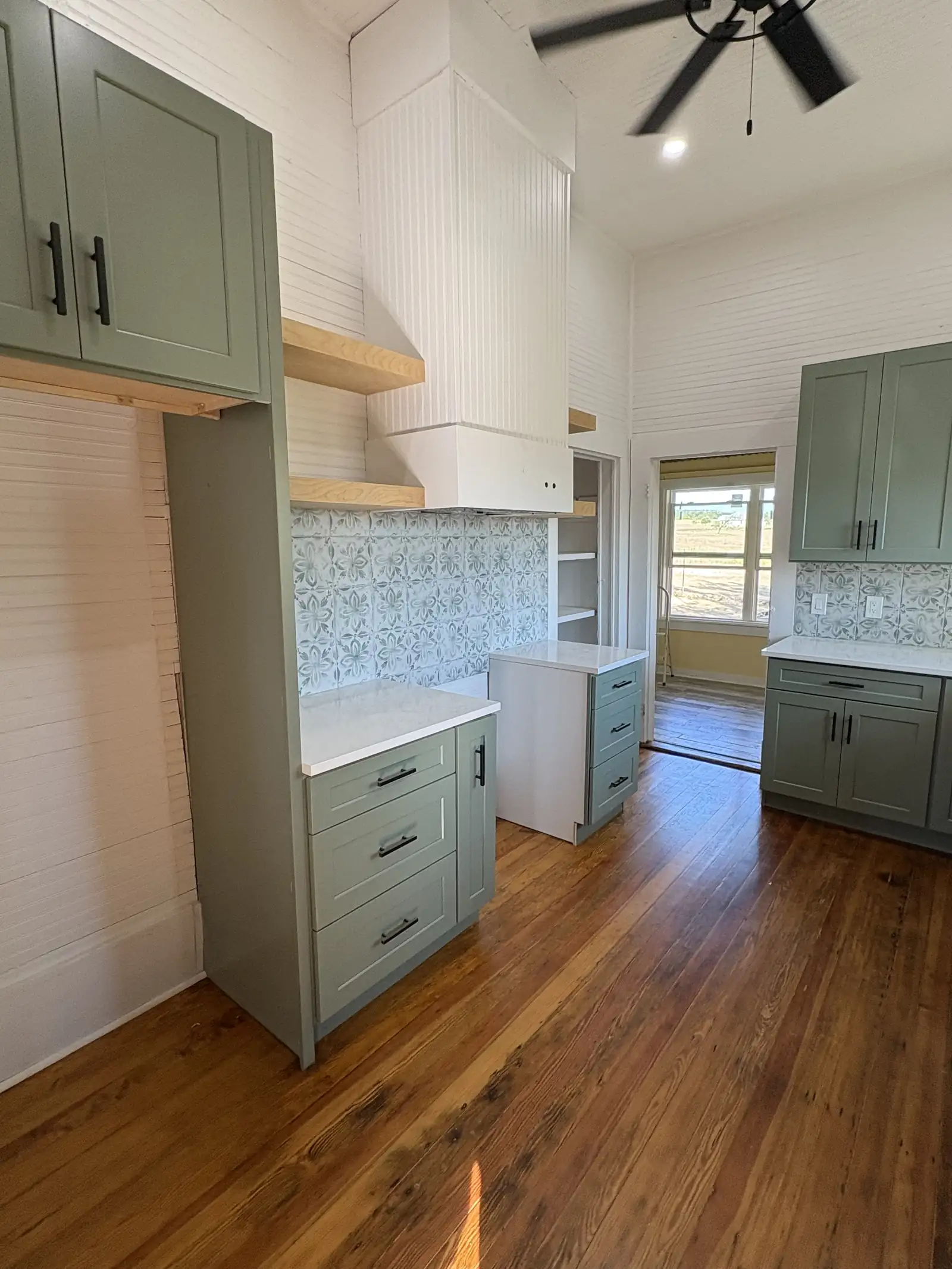 Farmhouse kitchen with open wood shelving and patterned tile