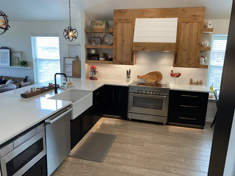 Charcoal kitchen cabinets and stained wood range hood