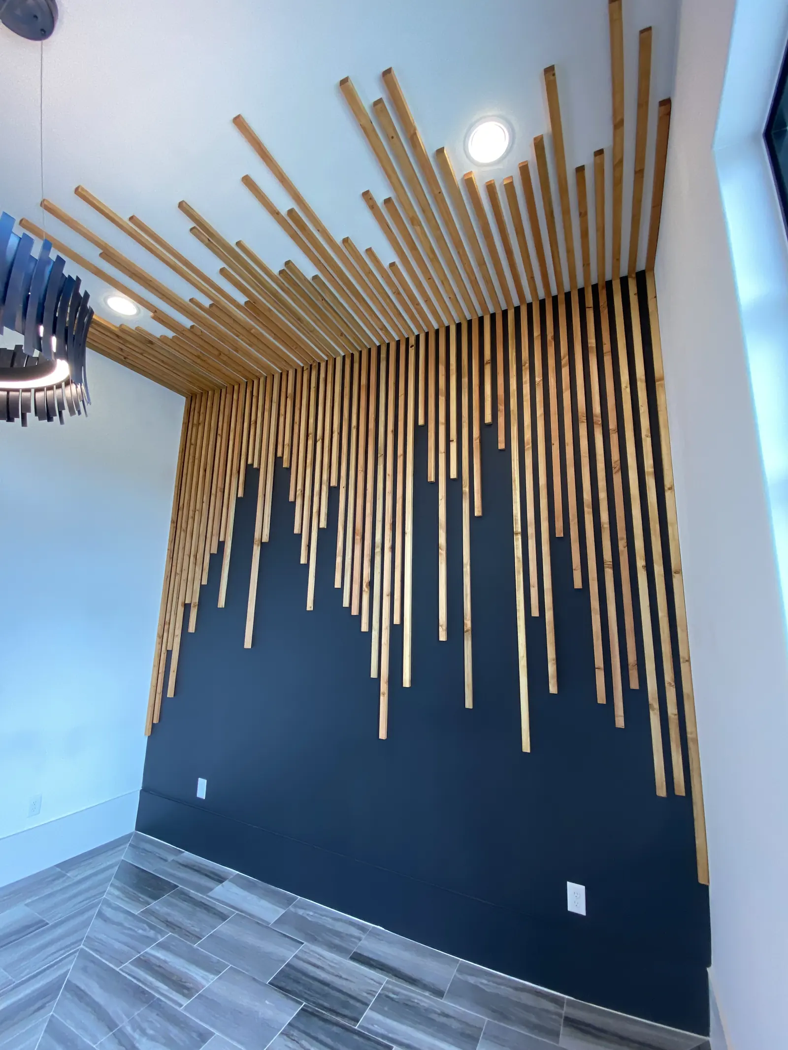 Vertical dowel feature wall installation in progress against a dark wall