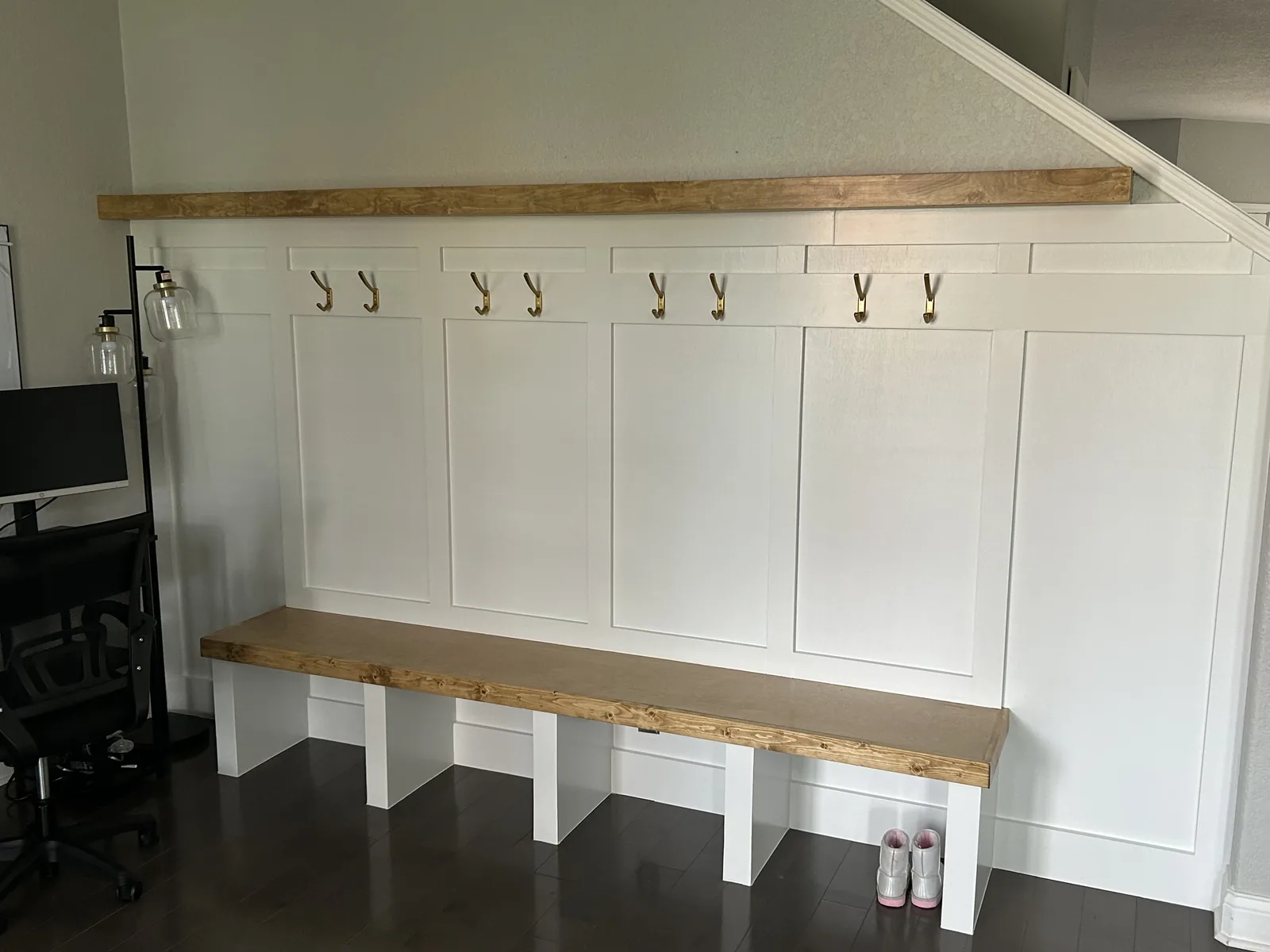 Finished mudroom lockers with a wood bench and panelled surround