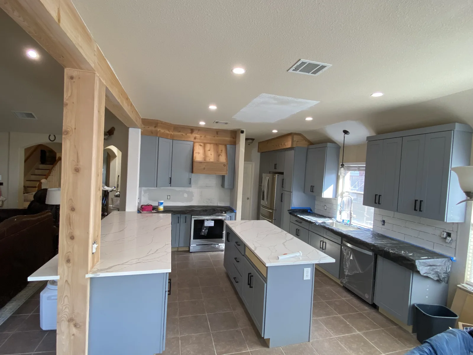 Schertz kitchen with blue grey cabinets, white quartz and exposed cedar beams
