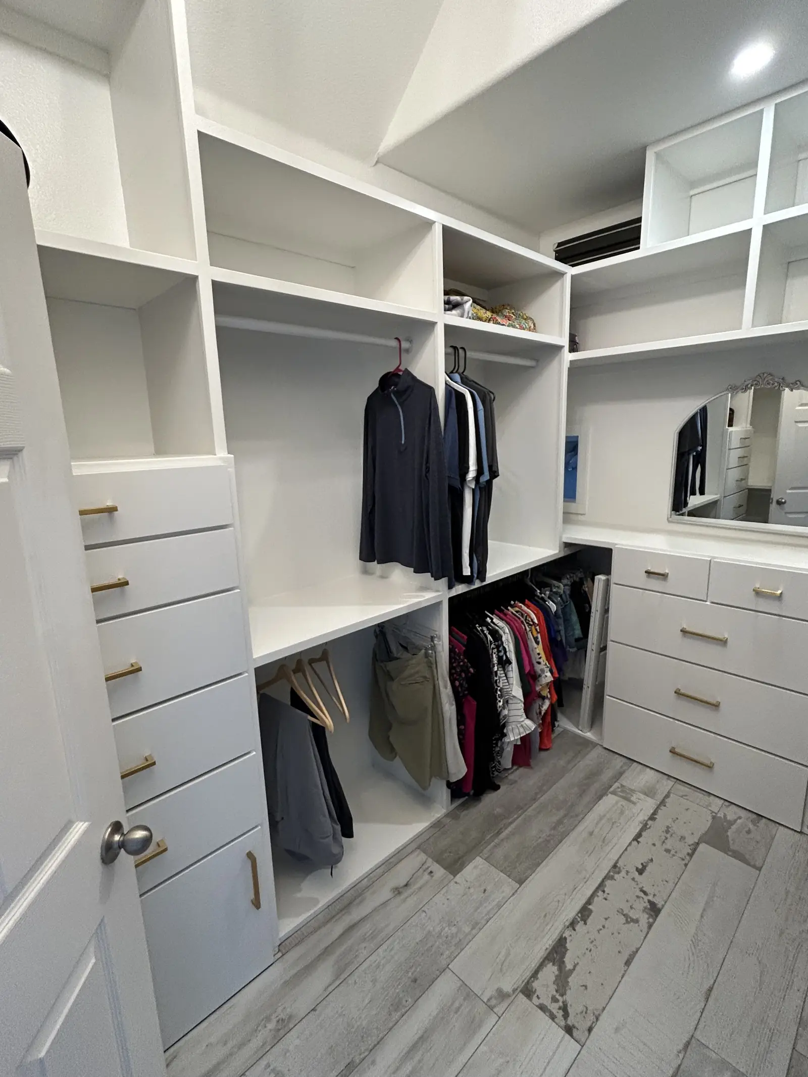 Finished walk in closet with built in drawers and hanging