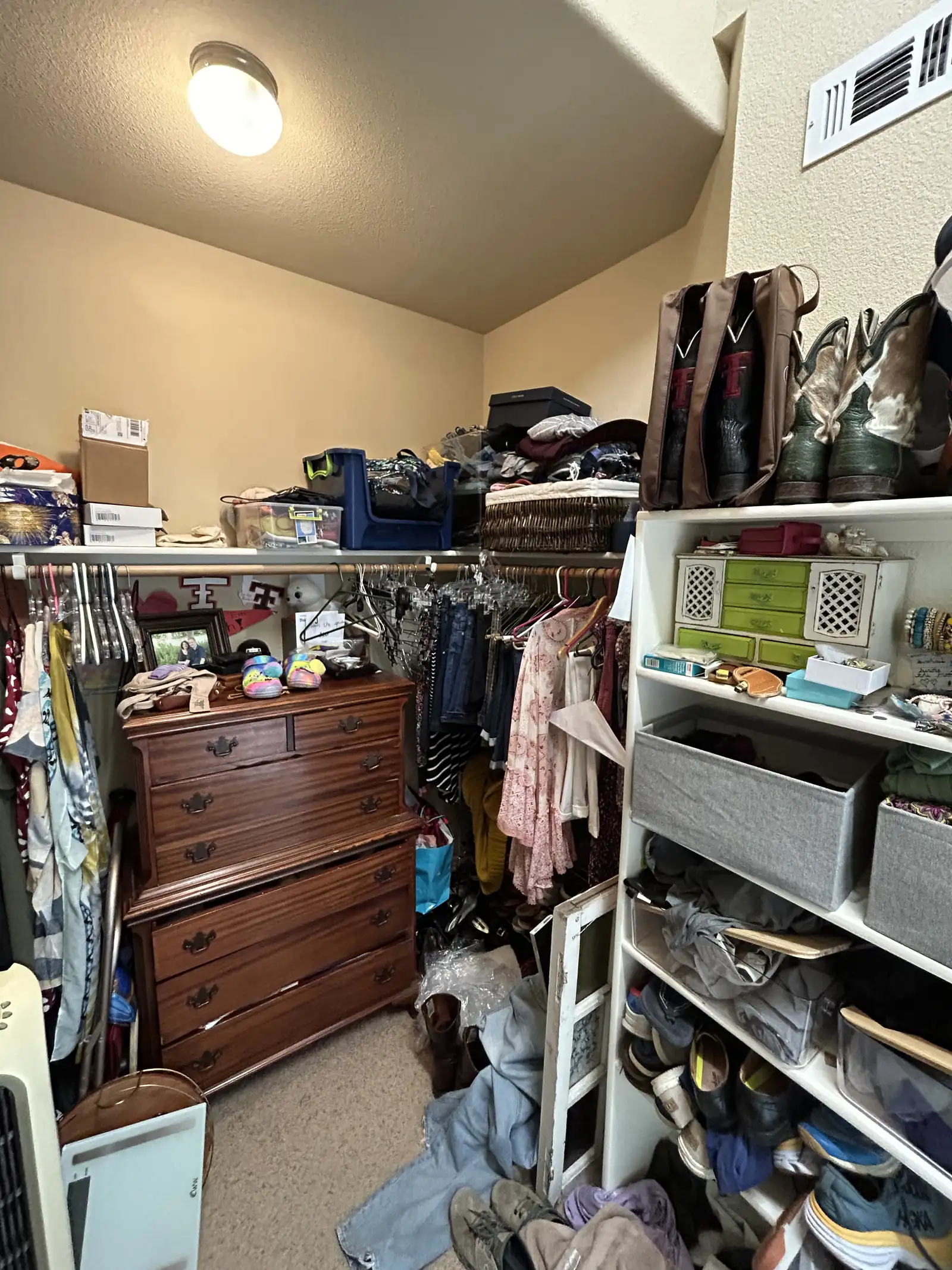 Cluttered walk in closet before remodeling with wire shelving