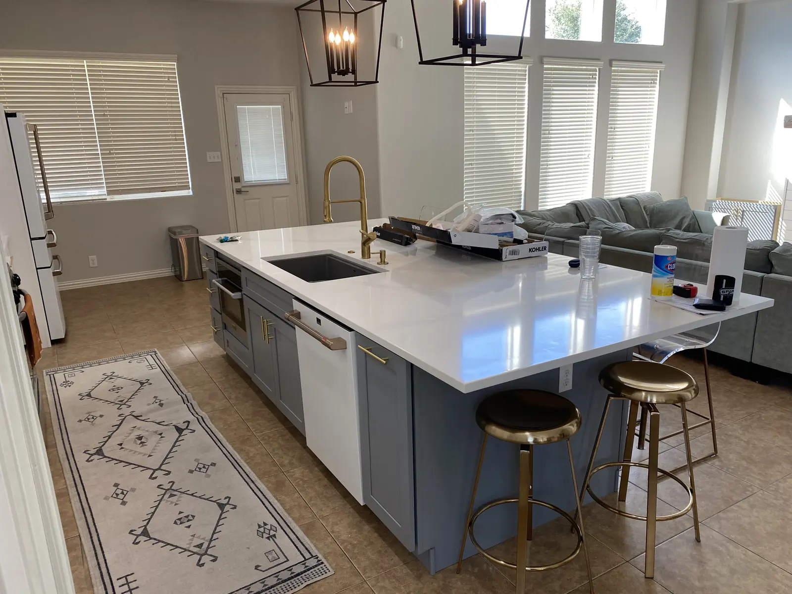 White shaker kitchen with a grey blue island and stainless appliances