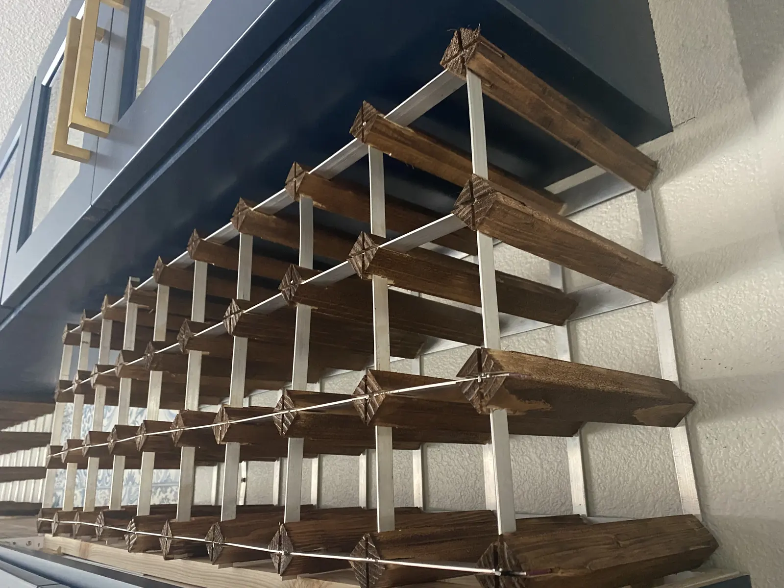 Close up of a hand built wine rack with angled bottle cradles in stained wood