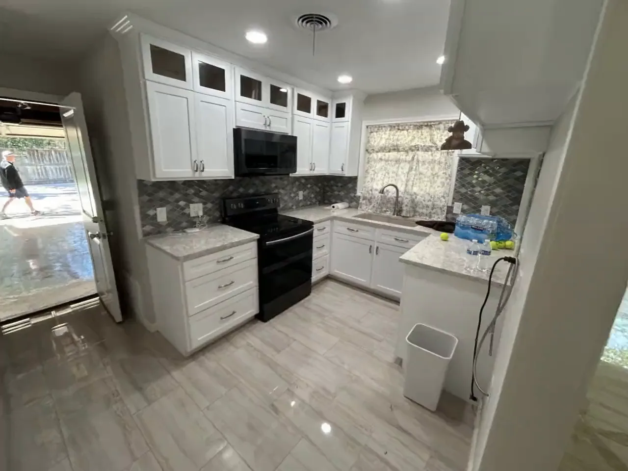 Hollywood Park kitchen before remodeling, closed off with dark backsplash and dated cabinets